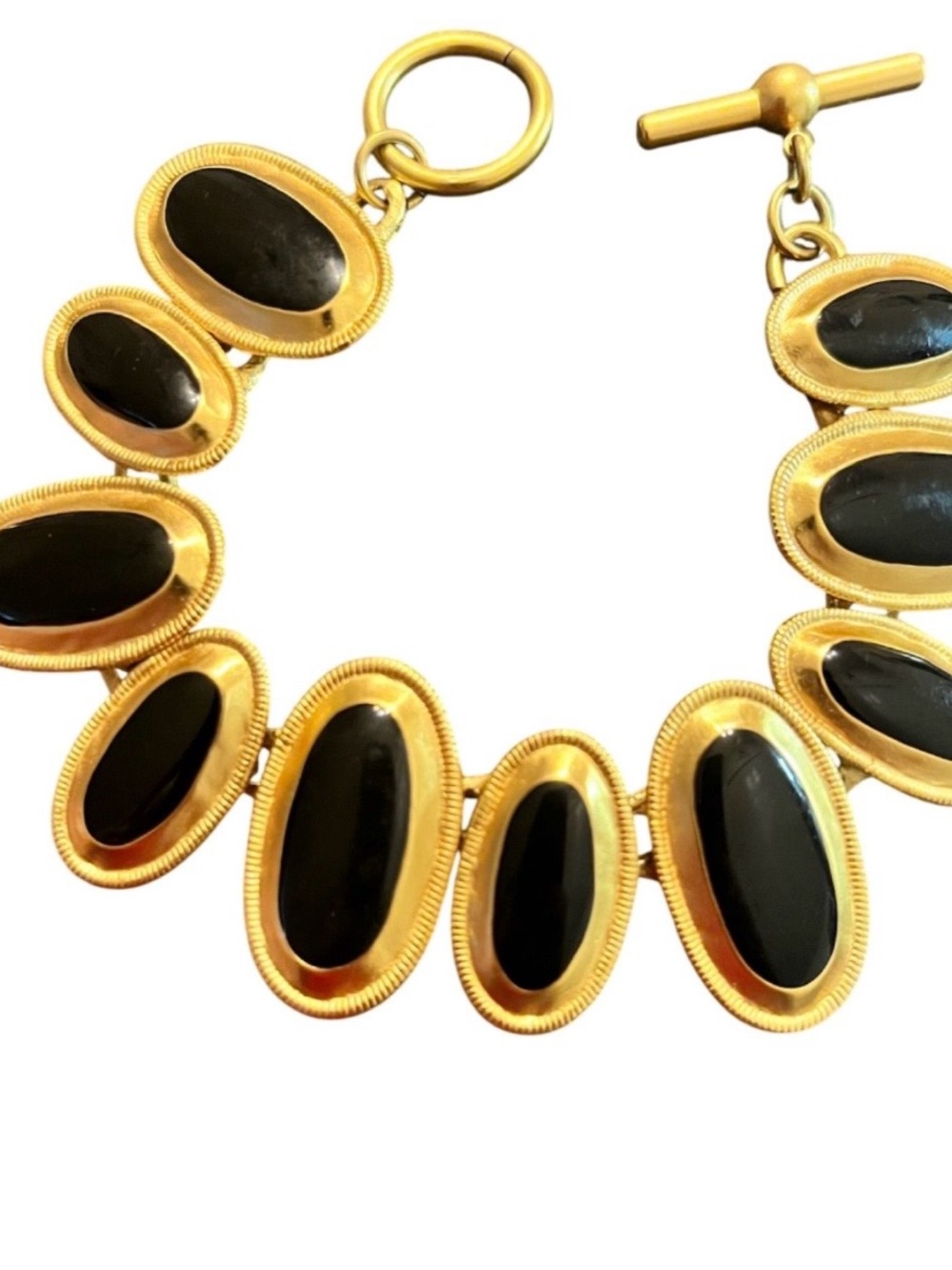 Anne Klein. Gold-tone settings hold oval black cabochons. Toggle clasp